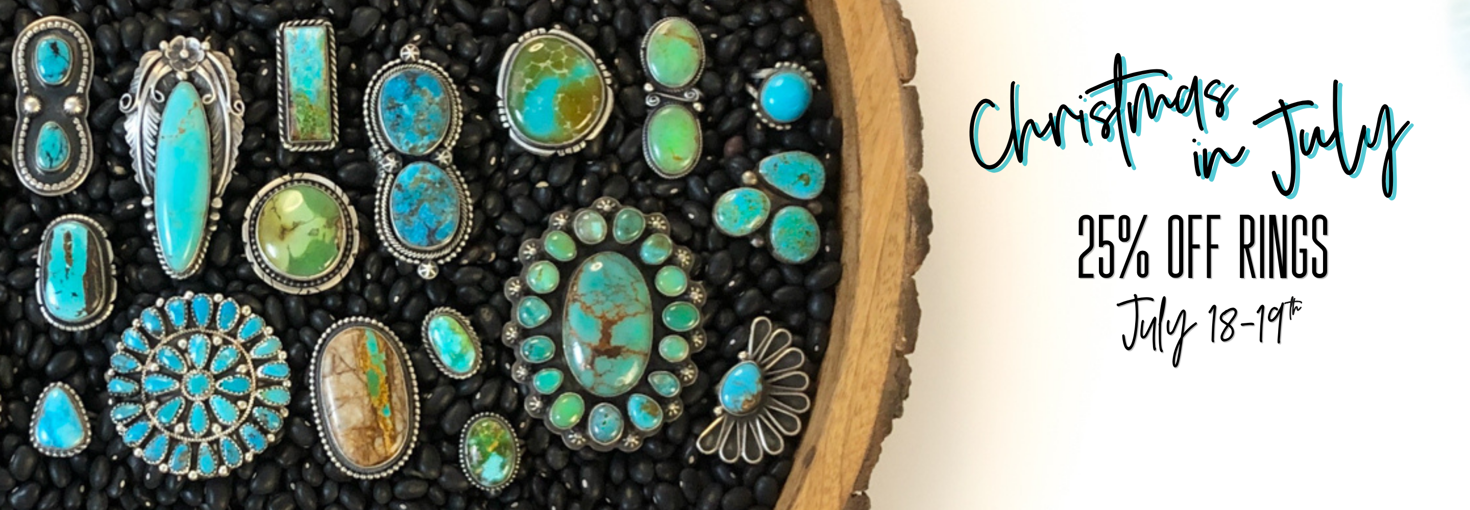 A promotional banner showing multiple turquoise and green stone rings arranged on a black textured surface with a wood slice edge, alongside text reading 'Christmas in July', '25% OFF RINGS', and 'July 18-19*'.