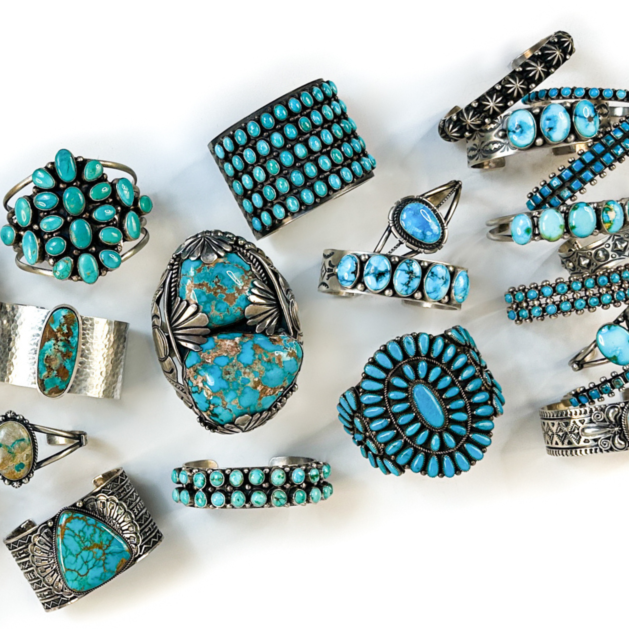Collection of turquoise and silver bracelets on a white background